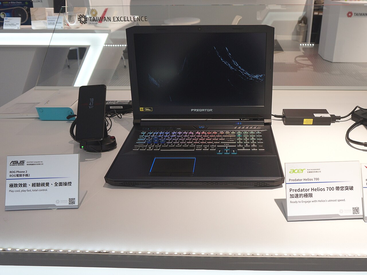 A gaming phone next to a gaming laptop on a desk